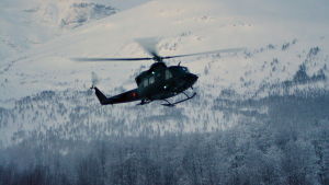 En helikopter flyger vid ett fjäll i Norge.