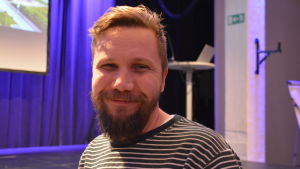 Roni Collin känner sig inspirerad efter diskussionsmötet. En man tittar in i kameran och ler.