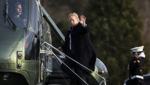 Donald Trump reste till hälsokontrollen med helikopter. Vinkande president Trump på väg upp i helikopter.