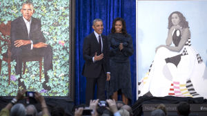 Michelle och Barack Obama i olja i Washington DC har blivit publiksuccé. Storleende Barack och Michelle Obama på scen av sidan av de nymålade porträtten av dem i Washington DC.