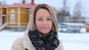 Annika Heikkilä är tacksam över personalen i Kristinestad. En kvinna med axellångt ljust hår står på en skolgård. Marken är täckt med snö.