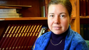 Evgeenia Bogdanova bor i Lappvik men studerar i Karis. kvinna i svart och blått invid bokhylla