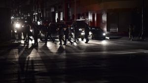 Mörk gata i Venezuelas huvudstad Caracas. Människor korsar en gata under elavbrott i Caracas 7.3.2019