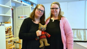 Beatrice Bäcklund och Carmela Johansson med maskoten, katten Taito. Två kvinnor md en tygkatt i handen.