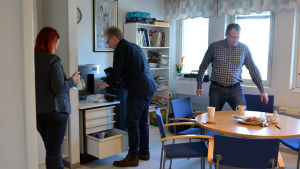 Företagarna Maria Norrlin-Asplund, Arno Gräsbeck och Christer Nyberg i det gemensamma pausrummet. Tre personer stöka runt i ett pausrum.