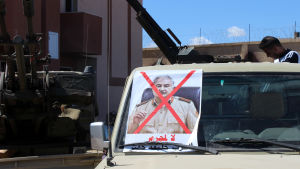 Milisgrupperna i västra Libyen som försvarar regeringen i Tripoli befarar att Haftar försöker bli en ny diktator så som Muammar Ghadafi Fordon med en överkorsad bild som föreställer Khalifa Haftar, ledare för LNA-armén i Libyen
