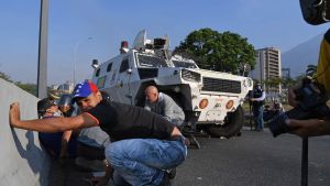Människor söker skydd under en eldstrid mellan oppositionsanhängare och regeringstrogna soldater i Caracas