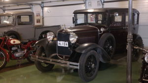 Den första bilen Anders renoverade var den här Forden. En gammal ford står i ett garage bredvid en röd moped