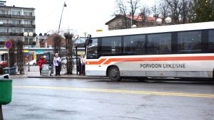 Arkivbild. En buss som det står Porvoon Liikenne på står vid en hållplats på torget i Borgå. Några personer ska stiga på.