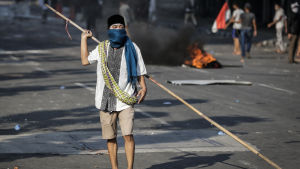 En demonstrant som beväpnat sig med en lång bambukäpp under sammandrabbingarna i Jakarta