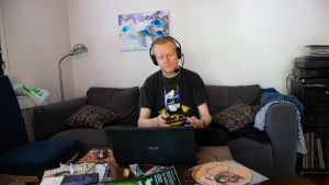 DJ Finnjävel dyker upp när familjen sover. henrik Gustafsson med headset på huvudet sitter vid latop i sitt vardagsrum med skivor omkring sig.