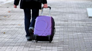 Den person som tagit med väskan har gjort sig skyldig till vårdslöshet. Kvinna drar en kappsäck efter sig