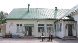 Det var vemodiga miner då Rödskog skola tömdes på leksaker och böcker. Den äldre delen av skolbyggnaden är byggd 1917, medan en tillbyggnad uppfördes 1958. En gammal vit skolbyggnad i trä med grönt koppartak. Framför huset står ett bord där tre kvinnor dukar upp kaffekoppar.