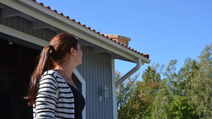 Therese Hahn fick oväntat besök av bin. En kvinna ser upp mot taket som ockuperats av en svärm med bin.