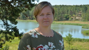Siv Vesterlund-Karlsson gläds över fredandet. Siv Vesterlund-Karlsson står i skuggan av en tall, i bakgrunden syns havet.