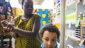 Harriet Aryenda  laittaa Sandoo Mäenpään hiuksia