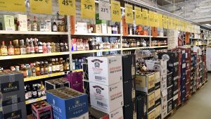 Den förra regeringen höjde alkoholskatterna både för svaga och starka alkoholdrycker för ett par år sedan. Planerna var att under några års tid stegvis höja priserna på alkohol drastiskt. Bild från en alkoholbutik. På marken står lådor med vin och hyllorna i bakgrunden är fyllda med sprit.