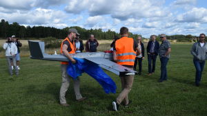 Drönaren bärs i väg för att bli omplåstrad efter utfört uppdrag. Drönaren bärs iväg