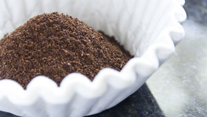Kaffesump fungerar bra som "body scrub", tipsar en läsare. Kaffe i en kaffefilter på ett mörkt bord.