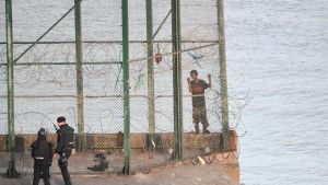 Några migranter fick skärsår då de klättrade över staketet.ö Migranter försöker ta sig från Marocko över till Ceuta