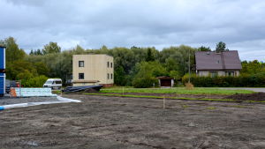 De här husen behöver tas bort för att få plats med allt nytt. två hus, en uppgrävd åker och träd i bakgrunden