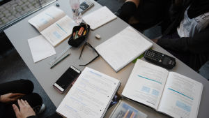 Men läget kanske ändå inte var så mörkt trots allt. Ett bord fyllt med studietillbehör, häften, miniräknare och pennor.