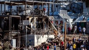 Flyktingar och migranter som samlats vid containrar som brunnit ner i en brand i det överfyllda lägret Moria. En kvinna och ett barn omkom i branden 29.9.2019. Lesbos, Grekland 30.9.2019. Flyktingar oich migranter som samlats vid containrar som brunnit ner i en brand i det överfyllda lägret Moria. En kvinna och ett barn omkom i branden 29.9.2019. Lesbos, Grekland 30.9.2019.
