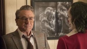 Robert De Niro som spelade huvudrollen i Taxi Driver och King of Comedy dyker här upp som talkshow-värden Murray Franklin. Närbild på Murray Franklin (Robert De Niro) som ser skeptisk ut då han ser på Joker.