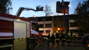 Brandkåren lyfter bort taket från den brandskadade byggnaden. Släckningsarbete vid höghus i Vasa.