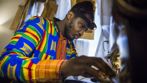 Dennis Owusu ompelemassa ompelukoneella