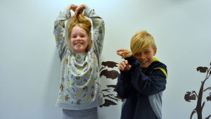 Här visar Svea Reuter och Eli Sihvonen hur man ser ut som en tandborste. en tjej håller upp håret och en kille har händerna framför sig - de försöker likna en tandborste