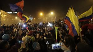 President Lenin Moreno ( i bakgrunden) nådde en kompromiss i försoningssamtal med representanter för Ecuadors ursprungsfolk Folksamling i Ecuador. Bilden är tagen på kvällen och man ser ett hav av människor och en handfull av landets flaggor, mobiltelefoner och vad som ser ut att vara en vuvuzela.