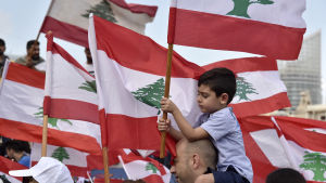 En liten pojke i flagghavet i Beirut på söndagen. Libanesiskt barn bland flagghavet i Beirut på söndagen.