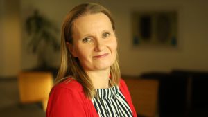 Marketta Lundell säger att man inte kan lyfta ett bostadslån vid kassan på samma gång som man köper veckans matuppköp. En dam i röd tröja ser in i kameran.