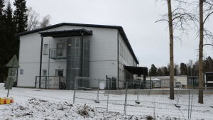 Den tillfälliga dagisbyggnaden byggdes under sommaren. En vit dagisbyggnad i snöigt landskap.
