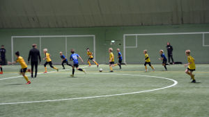 Matchen mot Inter slutade den här gången med förlust för ÅIFK. Fotbollsspelare från åifk p11-laget och FC Inter spelar fotboll på en fotbollsplan inomhus.