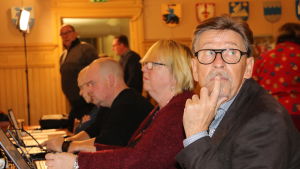 Carl-Gustav Mangs och övriga SFP.are anser fortfarande att fel beslut fattades då staden inte gick samman med Närpes i december förra året. En rad med personer sitter vid ett bord med datorer framför dem. I förgrunden en man glasögon.