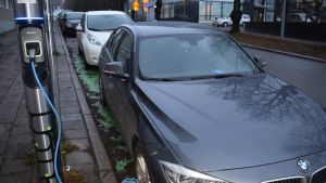 Ladattava hybridi latausasemalla kiinni pistokkeessa.