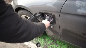 Då laddningen pågår är kontakten i låst läge och ska då inte lösgöras. Mies kokeilee, että ladattavan hybridin kaapeli on kiinni.
