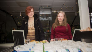 Opiskelija Minna Inkinen (vas.) hyvittää usein lounaansa ilmastopäästöt. Roosa Kiiskilä pitää kompensointimahdollisuutta tärkeänä, vaikka ei itse sitä juuri käytä. Opiskelijat lounasruokalassa.