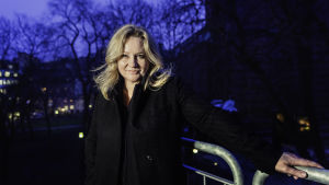 Maria Sid på sin lilla balkong, med S:ta Clara kyrka i den dunkla bakgrunden. Maria Sid i Stockholm 2019.