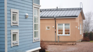 Företagarnas energilösningar har prövats på Sagobackens daghem i Borgå sedan 2016. Arkivbild. Ett blått trähus och ett brunt rappat hus står på en gård. I det bruna husets fönster finns julljusstakar.