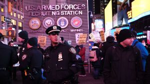 President Trump har sagt upp kärnvapenavtalet med Iran. Hemma i USA har han fått både kritik och beröm. Här en demonstration i New York. Antikrigsdemonstranter och poliser utanför armerekryteringsstation vid Times Square i New York.