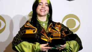 Billie Eilish tog i fjol hem vinsten i alla fyra huvudkategorier. Billie Eilish ler brett med fyra Grammy-staytetter i famnen.