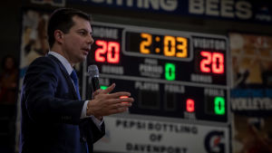 South Bend-borgmästaren Pete Buttigieg har storsatsat på att föra kampanj i Iowa. Ett gott resultat i delstaten anses av många bedömare vara en förutsättning för att Buttigieg ska ha chans att vinna nomineringen. Man i blå kostym håller tal och gestikulerar med handen. Mannen är Pete Buttigieg.