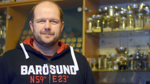 Krister Holmberg bland sina priser. Personporträtt på Krister Holmberg