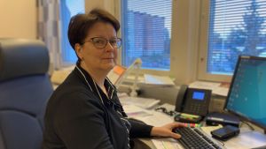 Monika Björkqvist, chef för äldreomsorgen i Korsholm. Kvinna sitter framför dator i kontorsrum.