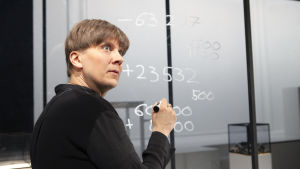 I dramatiseringen av Mitt kapital på Q-teatteri spelar Eero Ritala den kvinnliga huvudpersonen som har många likheter med Milja Sarkola själv. En man står framför en glasvägg och skriver siffror i vit tusch på glaset.