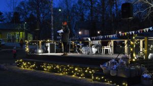 Jani Toivola var konferencier på Fria 2020. En man står på en vackert upplyst scen ute i en park.