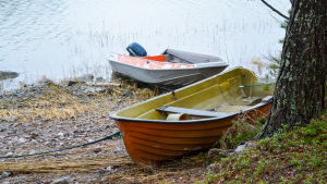 På andra försöket kom vi över till Käldö. En motorbåt och en roddbåt ligger uppdragna på en strand.
